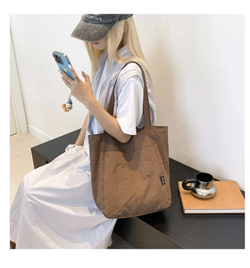 Detail of coffee brown tote bag with two front pockets and durable canvas material