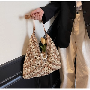 Detail of woven tote bag with pearl chain strap and unique triangular design