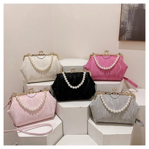 Close-up of pearl handles and metal frame on pleated velvet shell bags in five colors