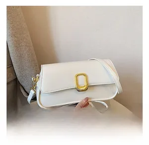 Detail showing the white leather square bag with elegant golden textured metal lock buckle