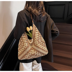 Detail view of woven tote bag featuring hollow knit patterns and pearl chain strap decoration