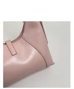 Close-up of pink leather texture and stitching detail on the minimalist crescent handbag
