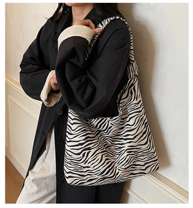 Action shot of a zebra print canvas tote bag styled with a minimalist outfit