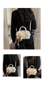 Detail of cream leather handbag featuring a cute brown horse charm and slim shoulder strap