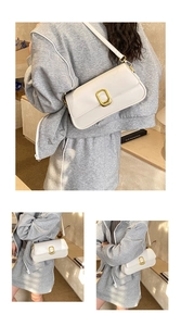Macro view of vintage cream white baguette bag featuring polished gold square metal buckle