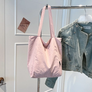 Detailed close-up of a light pink minimalist tote bag made of durable nylon material