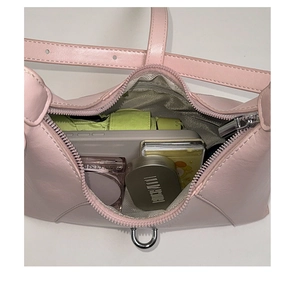 Internal view of a pink leather crescent bag showing ample storage for daily essentials