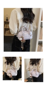 Detail view of light purple Boston bag with plush horse charm and glossy leather texture