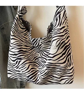 Close-up of zebra print canvas bag featuring a stylish knotted shoulder strap detail