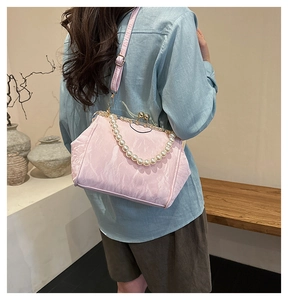 Chic pink textured shell bag featuring pearl handle and vintage metal frame clasp closure