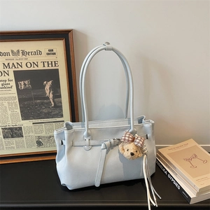 Close-up of light blue faux leather tote bag with lychee texture and bear charm