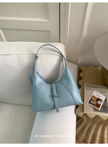 Detail of light blue crescent hobo bag with silver buckle and adjustable shoulder strap