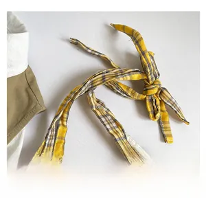 Detailed macro view of yellow and gray plaid fabric texture with a hand-knotted strap