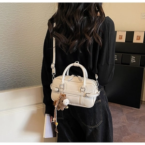 Model view of cream white faux leather bowling bag with horse pendant detail