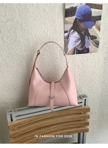 Detailed close-up of a pink hobo bag with a silver metal buckle and soft leather texture