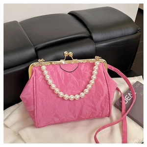Detail of rose pink pleated shell bag with large pearl handle and vintage metal clasp