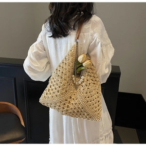 Detail of bohemian woven straw tote bag with elegant pearl chain and leather strap