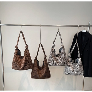 Detail of four canvas tote bags with various animal patterns like leopard and zebra prints
