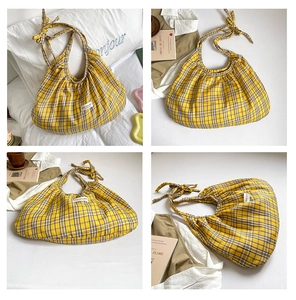 Detailed view of yellow plaid shoulder bag featuring soft ruffles and adjustable knotted strap