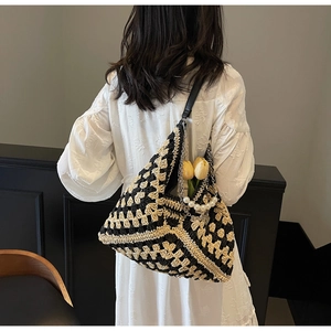 Detail of hand-woven checkerboard tote bag with pearl chain and leather straps