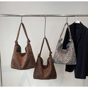 Detail of leopard and zebra print canvas tote bags with stylish knot handle accents