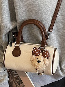 Vintage beige boston pillow bag with brown handles and a cute teddy bear charm