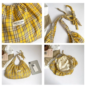 Detail of yellow checkered tote bag showing woven label and inner storage pocket