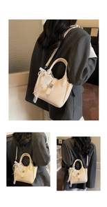 Close-up of cream bucket bag showing lychee texture, silver twist lock and pearl lace charm