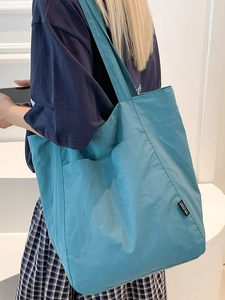 Minimalist large capacity tote bag in blue nylon fabric with wide shoulder straps