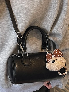 Vintage black cylinder boston bag with teddy bear charm shown on casual outfit
