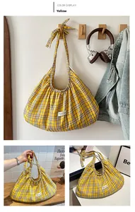 Detail of yellow checkered tote bag with pleated fabric and knot shoulder strap