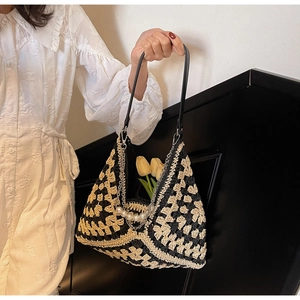 Detail of woven tote bag with monochrome crochet texture and pearl chain charm