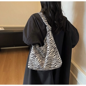 Detail of zebra print tote bag featuring a stylish knotted strap design and hobo style