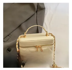 Dettaglio borsa trapuntata beige con catena in metallo dorato e doppia cerniera