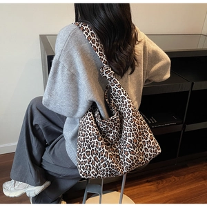 Detail of the knotted shoulder strap and leopard print fabric on a stylish hobo bag