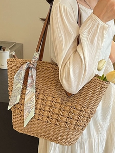 Large woven straw beach tote bag with leather straps and decorative scarf for summer