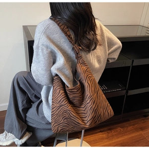 Detailed texture of zebra print tote bag with a unique handcrafted knot shoulder strap