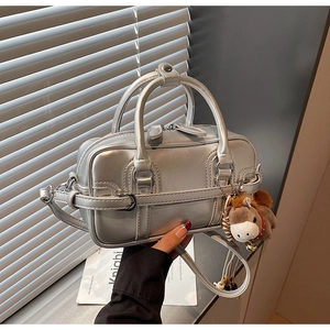 Detail of silver metallic Boston bag featuring mirror finish and brown plush horse charm