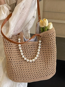 Handmade woven tote bag with pearl handle and brown leather strap for beach vacations