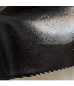 Macro shot of glossy black textured leather material with natural folds and fine details
