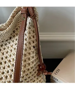 Detailed close-up of straw woven tote with leather strap and decorative amber beads