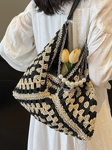 Handwoven black and white geometric tote bag with pearl handle and chain strap