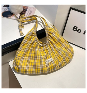 Detail of yellow plaid tote bag with twisted knot strap and vintage woven label