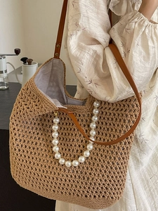Handmade woven straw tote bag with brown leather straps and elegant pearl handle detail