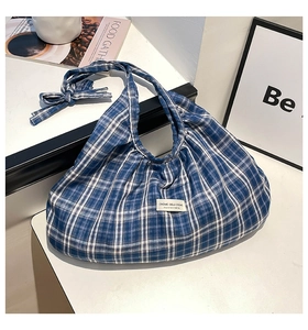 Detailed close-up of blue and white checkered tote bag with pleats and a bow decoration