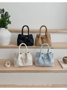 Detail view of textured basket tote bags in four neutral colors on wooden shelves