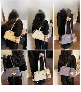 Detail view of stylish tote bags in cream and lilac with a cute bear plush charm
