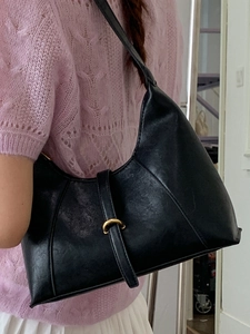 Classic black semi-circle underarm bag in matte leather with a gold buckle and shoulder strap