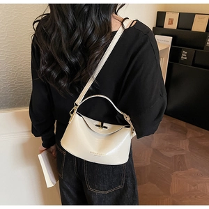 Chic cream leather shoulder bag with top handle shown in a stylish lifestyle setting