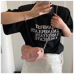 Détail du sac à bandoulière rose clair en forme de cœur avec boucle et chaîne argentée